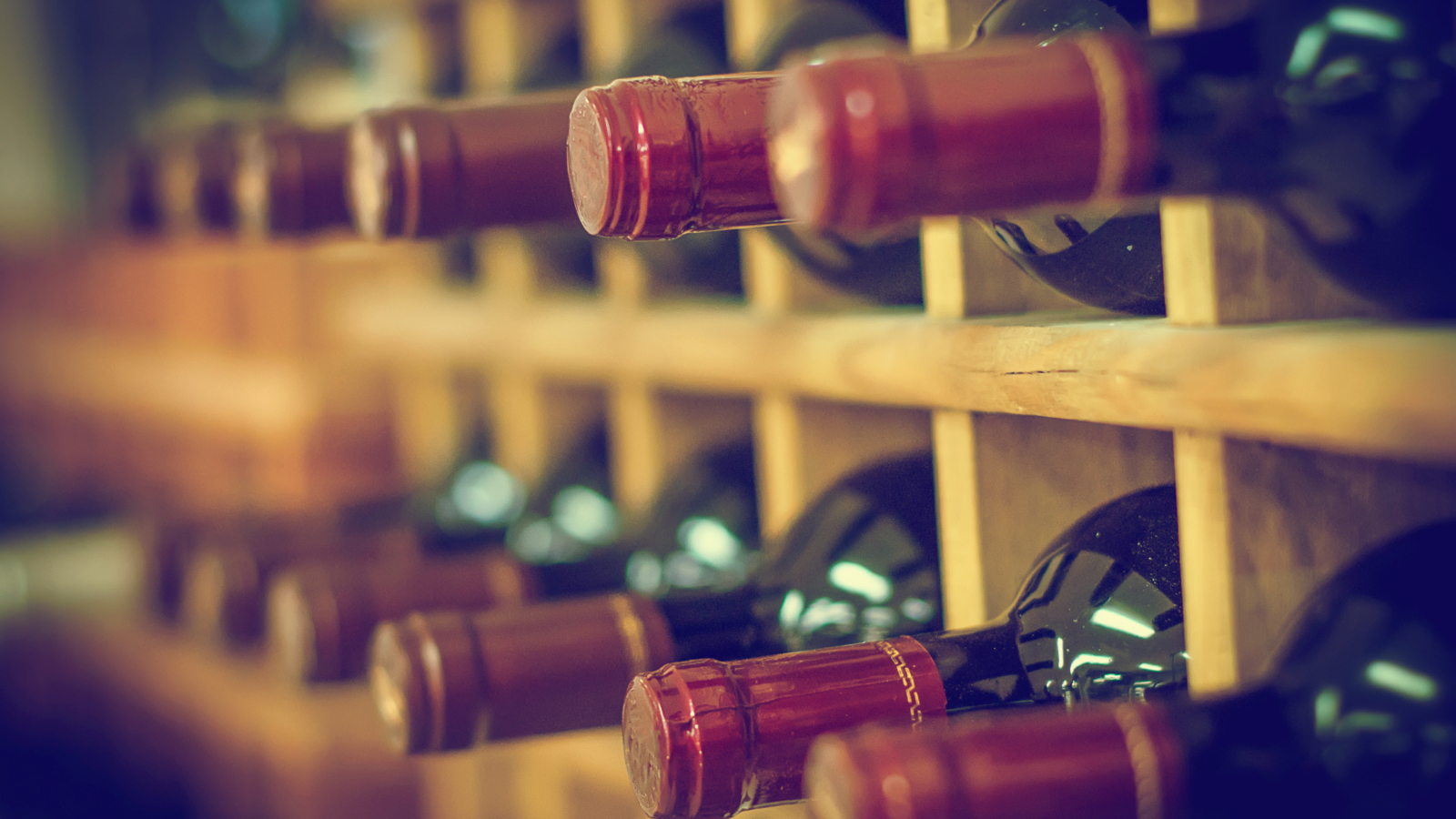 Red,Wine,Bottles,Stacked,On,Wooden,Racks