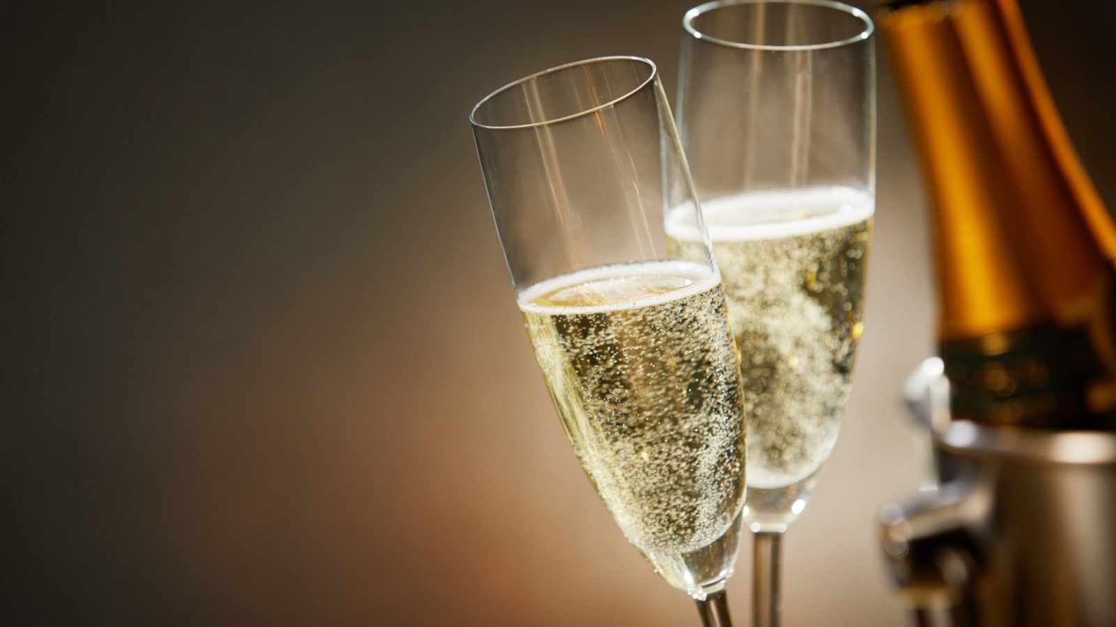 Two,Romantic,Glasses,Of,Sparkling,Champagne,Alongside,A,Bottle,In